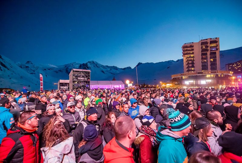 A big crowd outside at dusk at some kind of festival, in Tignes village