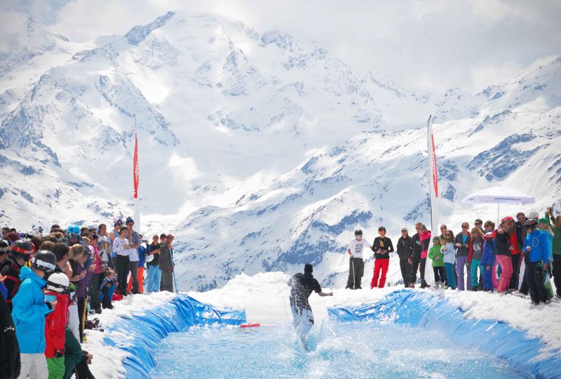 Pond skimming in the mountains, crowds on either side of water